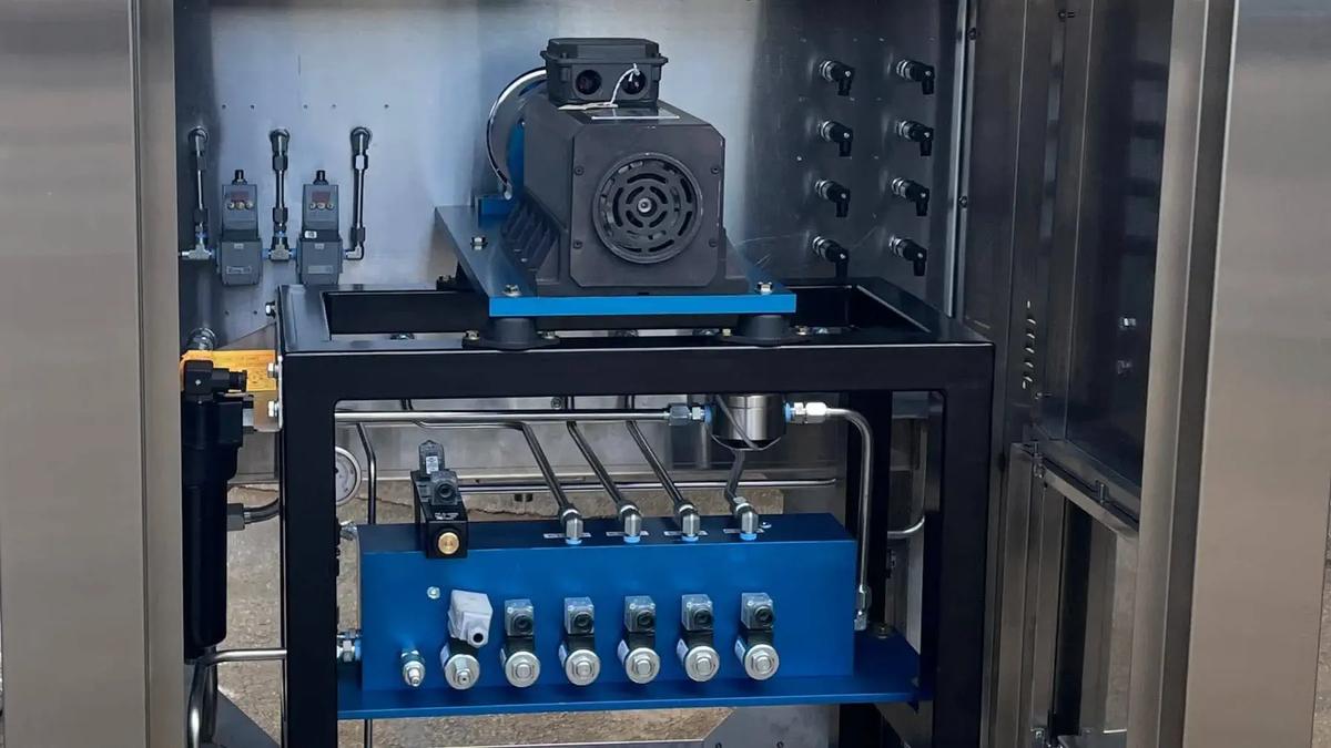 Test bench featuring a machine with a blue and black cover, revealing an internal manifold